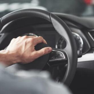 Мужская рука на руле автомобиля
